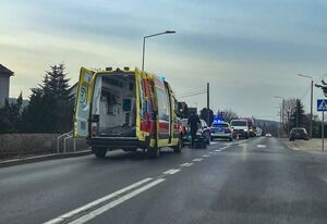 Zdjęcie przedstawia karetkę pogotowia oraz radiowóz stojące przy przejściu dla pieszych.