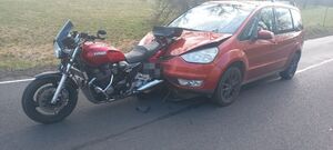 Zdjęcie przedstawia pojazd oraz motocykl, które uczestniczyły w zdarzeniu drogowym.