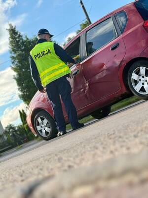 Zdjęcie przedstawia policjanta, przeprowadzającego badanie stanu trzeźwości na drodze.