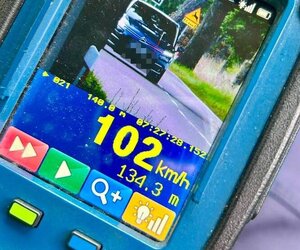 Zdjęcie przedstawia laserowy miernik prędkości z wizualizacją, na ekranie którego widać pojazd i zmierzoną prędkość - 102 km/h.