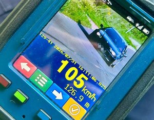 Zdjęcie przedstawia laserowy miernik prędkości z wizualizacją, który przedstawia pojazd BMW poruszający się z prędkością 105 km/h.