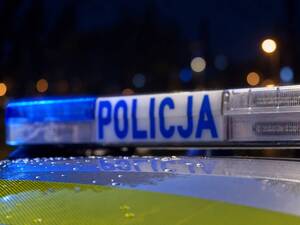 Zdjęcie przedstawia belkę pojazdu uprzywilejowanego z napisem POLICJA w porze nocnej.